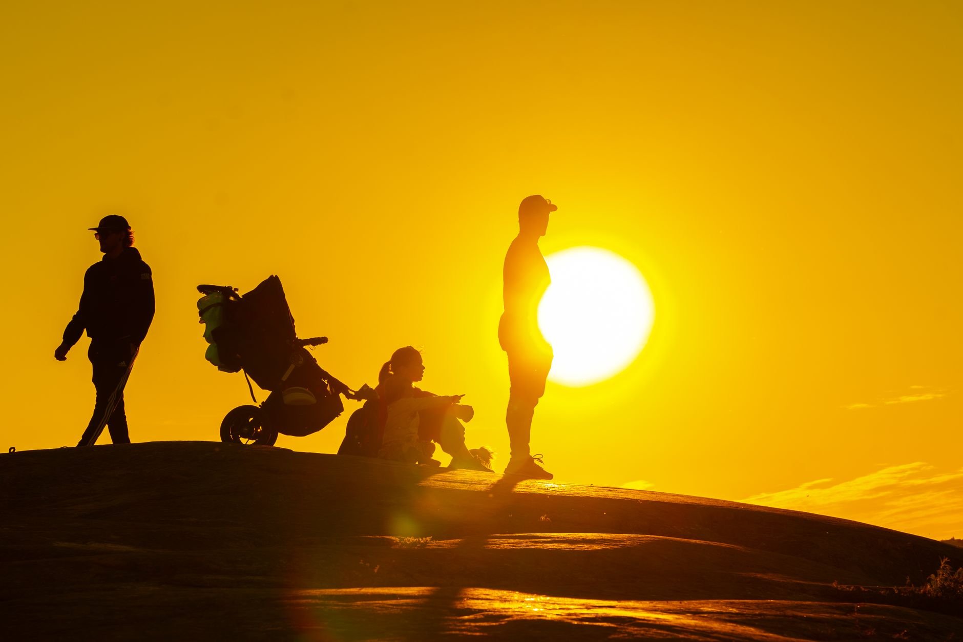 Family silhouetted against a golden sunset, capturing a serene outdoor moment